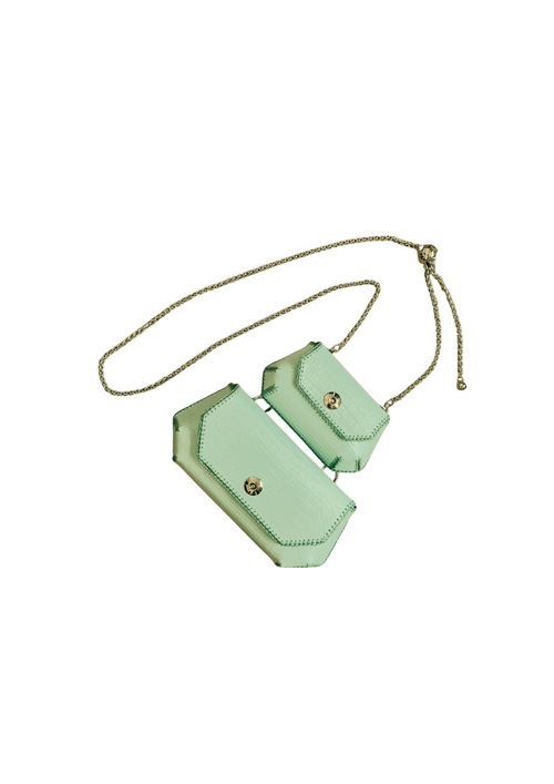 Mint green crossbody bag with gold accents on a beige background